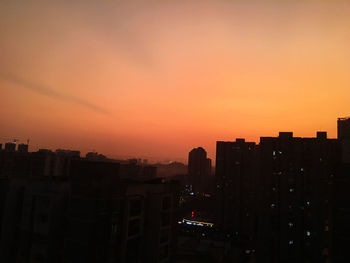 Silhouette buildings against sky during sunset