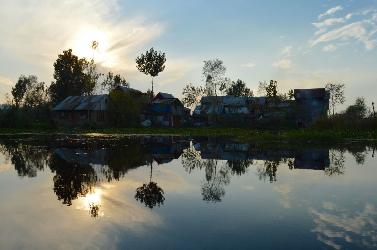 architecture, building exterior, reflection, built structure, water, tree, sky, waterfront, sunset, lake, palm tree, cloud - sky, house, cloud, nature, tranquility, growth, beauty in nature, tranquil scene, river