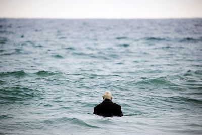 Rear view of man swimming in sea