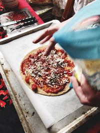 Close-up of hand holding pizza