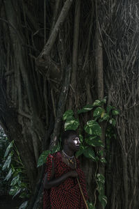 Maasai man in traditional clothes standing in the forest