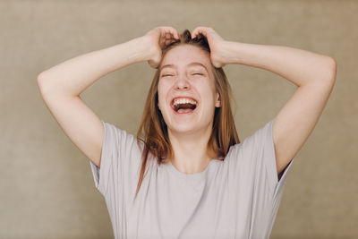 Portrait of smiling young woman looking away against black background