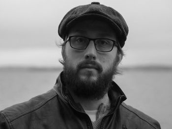 Portrait of young man wearing sunglasses against sea