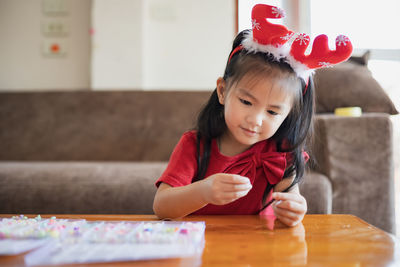 Cute girl making decoration on table