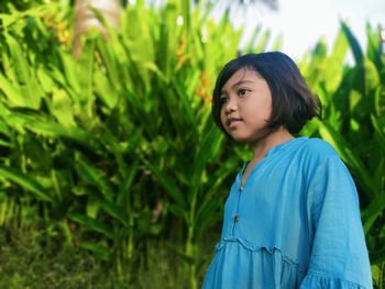 A smiling girl against a green plant background