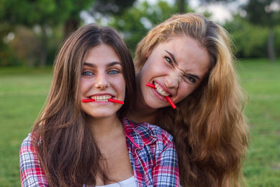 Portrait of young women eating candies on field