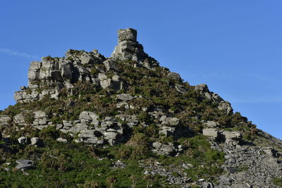 Low angle view of rocks against blue sky