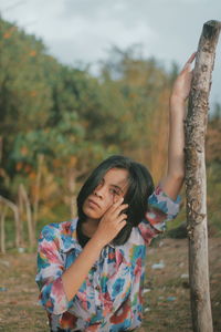 Full length of woman standing by tree