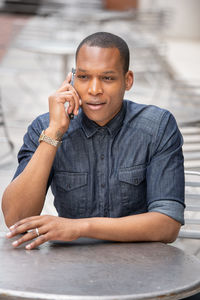 Portrait of young man sitting on table