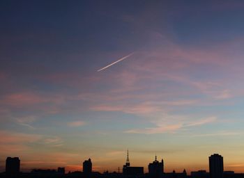 Silhouette cityscape against sky at sunset