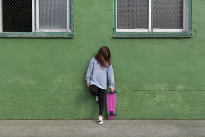 Full length of woman standing against building