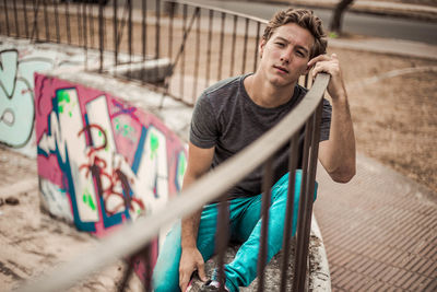 Young man standing on railing