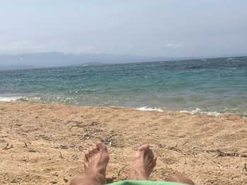 Low section of woman standing on beach