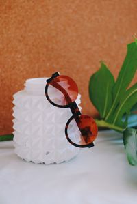 Close-up of eyeglasses on table against wall