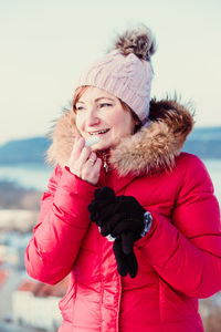 Smiling woman wearing winter coat and knit hat