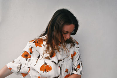 Woman standing against white wall