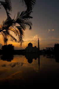 Reflection of built structure in water at sunset