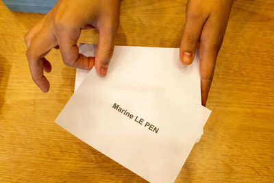 Cropped hand of woman holding paper