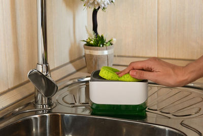 Cropped hand washing hands in sink