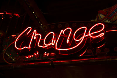 Low angle view of illuminated text on red light