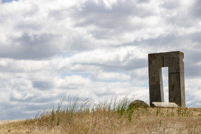 Low angle view of old ruin on field against sky