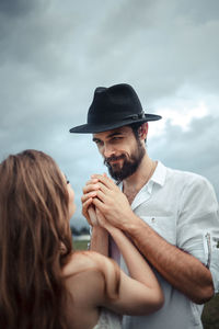 Smiling man holding hands of woman
