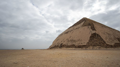 View of desert against cloudy sky