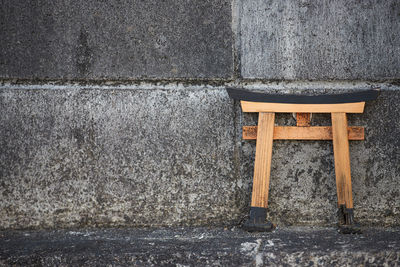 Small shinto shrine torii gate up on a concrete wall