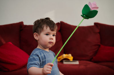 Curious little boy playing with a paper rose