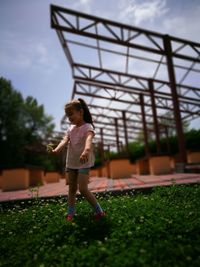 Smiling girl against built structure at park