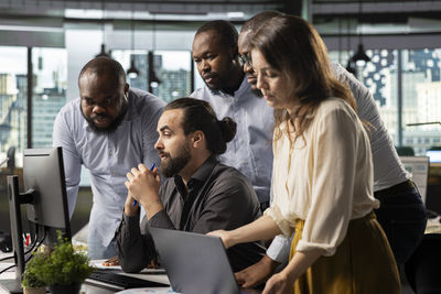 Friends using mobile phone while standing in cafe