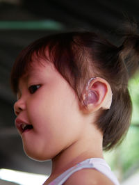 Close-up of cute girl wearing hearing aid