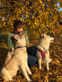 Full length of woman with dog on leaves during autumn