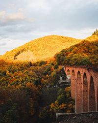 Arch bridge against sky during autumn