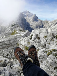 Low section of man wearing shoes against mountains