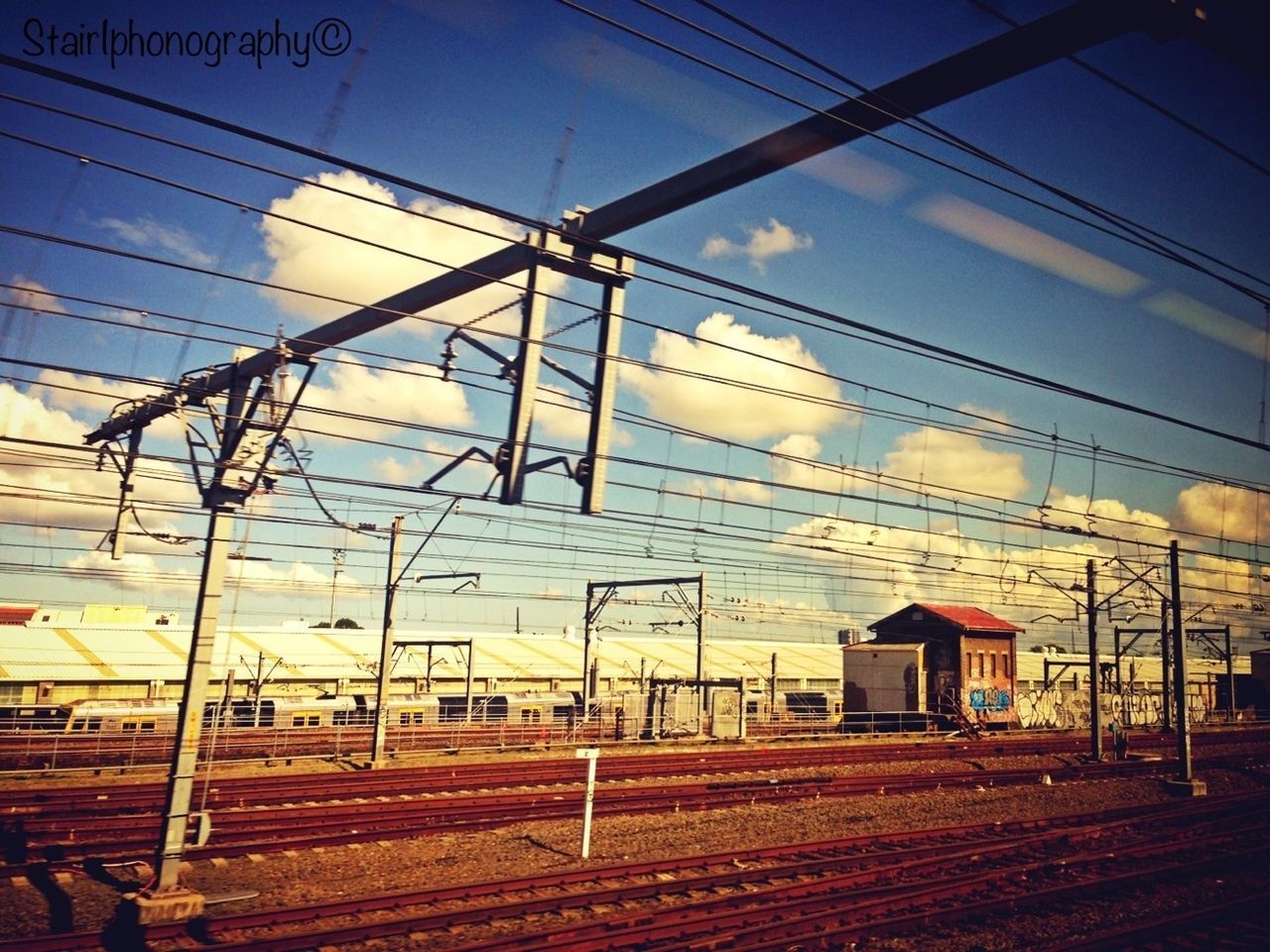 power line, electricity pylon, electricity, cable, power supply, built structure, railroad track, fuel and power generation, sky, building exterior, architecture, connection, power cable, blue, rail transportation, sunset, transportation, outdoors, railroad station, no people