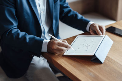 Male professional making business strategy on digital tablet in office