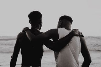 FRIENDS ON BEACH AGAINST SKY