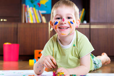 Portrait of happy boy sitting on table at home