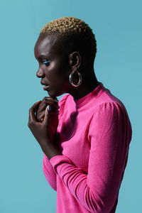 Side view of a pensive young african woman holding her chin with her hands while in a studio session