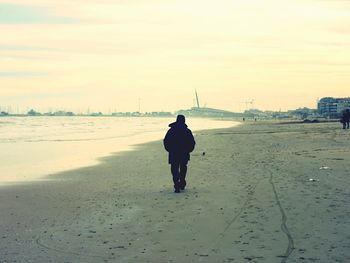 Silhouette of woman standing against sky at sunset