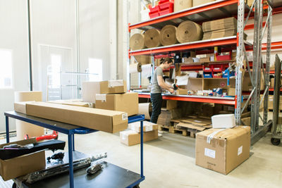 Manual worker packing box in distribution warehouse