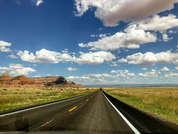 Road by landscape against sky