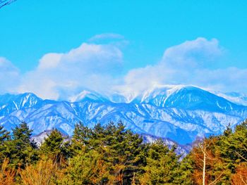 Scenic view of mountains against blue sky