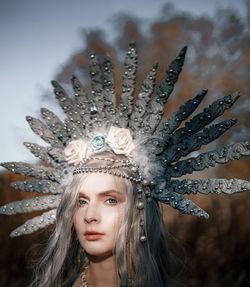 Portrait of beautiful woman wearing costume standing against trees