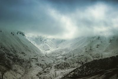 Scenic view of snow covered mountains against sky