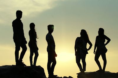 Silhouette people standing against sky during sunset