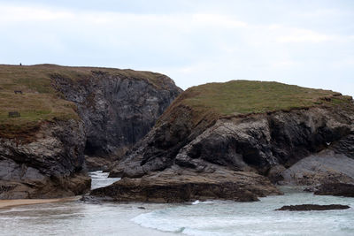 Rock formations by sea against sky