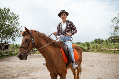 Full length of man riding horse on field