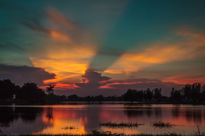 Scenic view of dramatic sky over lake during sunset